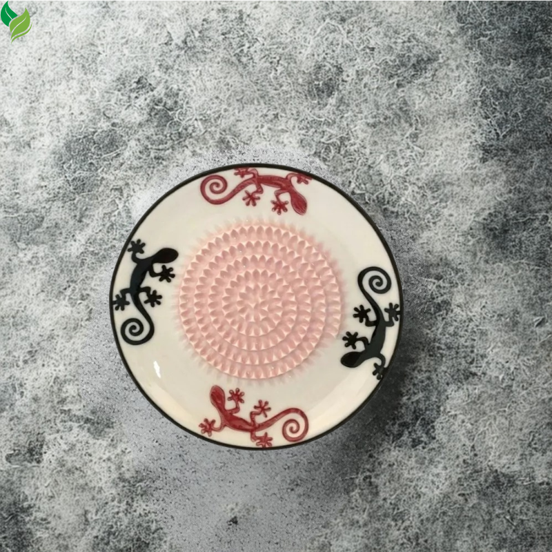 Close-up of raised ceramic teeth on a manual ginger grater plate