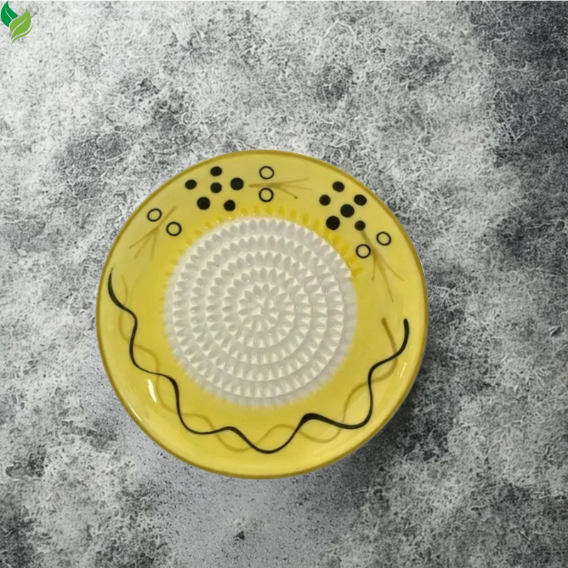 Manual ceramic grater used for preparing garlic on a kitchen counter