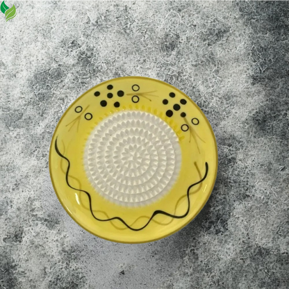 Manual ceramic grater used for preparing garlic on a kitchen counter