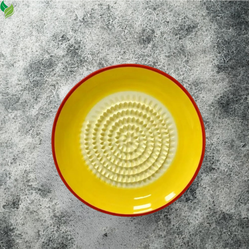 Small ceramic ginger grater plate held in an adult hand