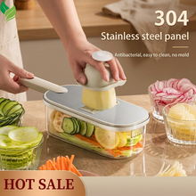 Multi-function vegetable cutter slicing cucumber and potato into a clear container